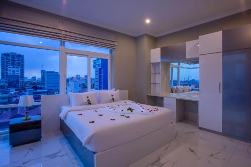 a bedroom with a large white bed and a window at SSB Residence in Phnom Penh