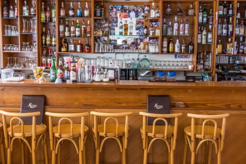 a bar with four stools in front of a counter at Missiria Apartments in Rethymno Town