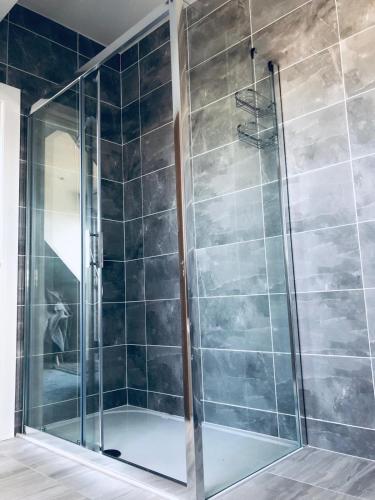 a shower with a glass door in a bathroom at Hillrise B&B in Portrush