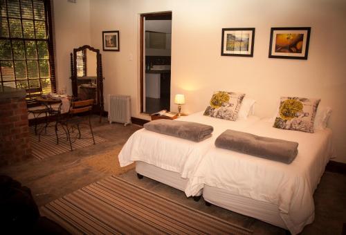 En eller flere senge i et værelse på Mooiplaas Wine Estate