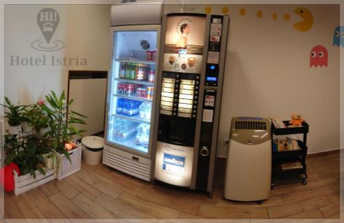 a large soda machine in a room next to a cooler at Hotel Istria in Trieste