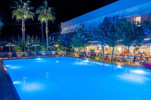 a large swimming pool in front of a building at night at Missiria Apartments in Rethymno Town