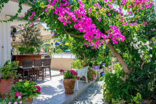a tree with pink flowers on a patio at Missiria Apartments in Rethymno Town