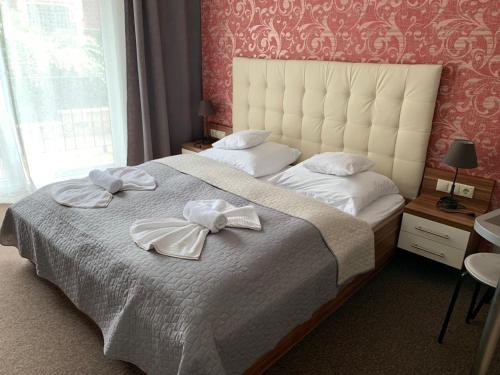 a bedroom with a large bed with two towels on it at Villa Mona Lisa in Hévíz