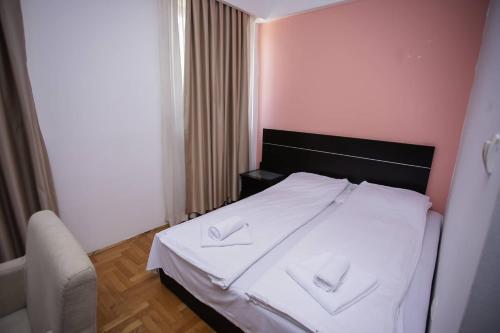 a bedroom with a bed with two white towels on it at Hotel Beograd - Yu in Sarajevo
