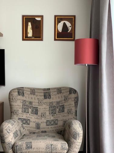 a living room with a chair and a lamp at Villa Mona Lisa in Hévíz