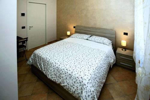 una camera con un letto e una scrivania con due lampade di B&B Passalacqua a Ortona