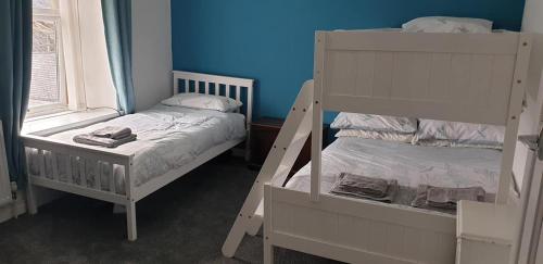 a bedroom with two bunk beds next to a window at Snowdonia miners cottage in Blaenau-Ffestiniog