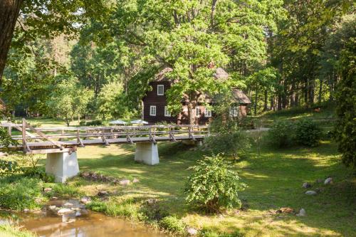 a bridge over a river in front of a house at Viesu māja Sprīdīši in Tērvete