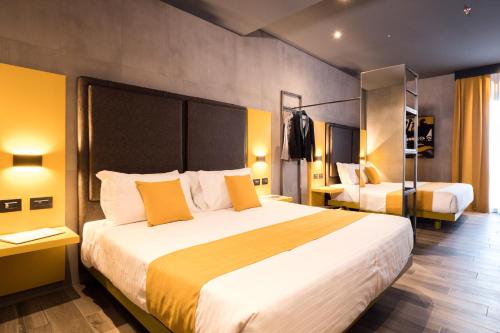 una camera d'albergo con un grande letto con cuscini gialli di J24 Hotel Milano a Milano