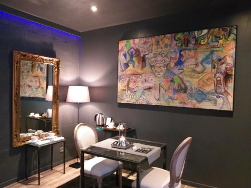 une salle à manger avec une table et des chaises et un tableau dans l'établissement Lorraine Badonviller, à Badonviller