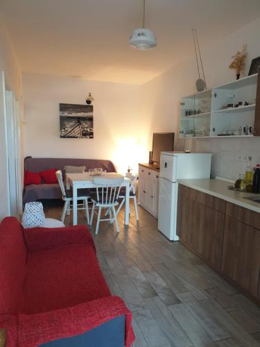 a kitchen and living room with a red couch and a table at Apartments Neda in Drače