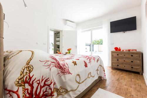 a white bedroom with a bed and a dresser at Vila Gallo in Galovac