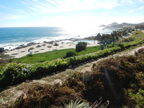 a view of a beach with umbrellas and the ocean at Departamento Puerto Velero in Puerto Velero
