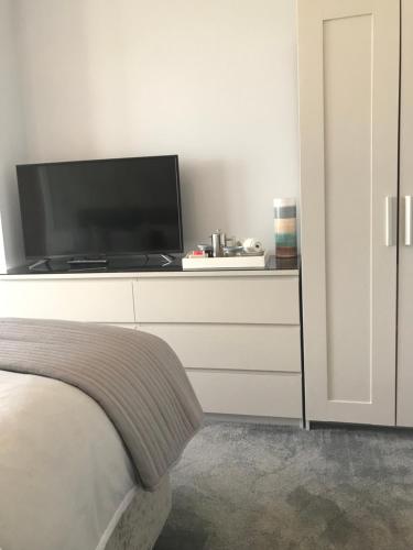 ein Schlafzimmer mit einem Flachbild-TV auf einer Kommode in der Unterkunft Hillrise B&B in Portrush