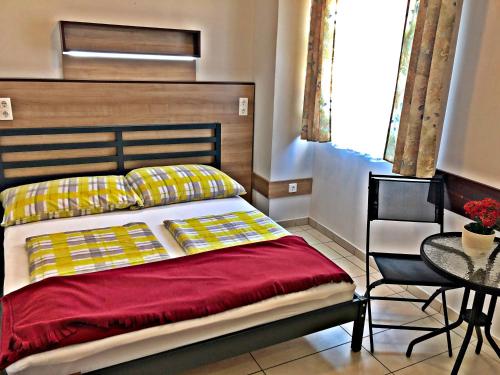 a bedroom with a bed and a table and a chair at Süle Apartments & Rooms in Balatonfüred