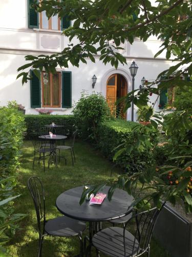 two tables and chairs in the yard of a house at Villa Della Certosa in Gambassi Terme