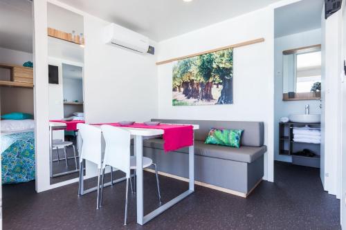 a room with a table and chairs and a sink at Vila Gallo in Galovac