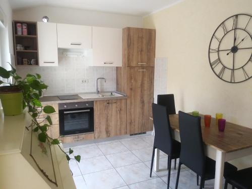 a kitchen with a table and a clock on the wall at Allegria in Umag