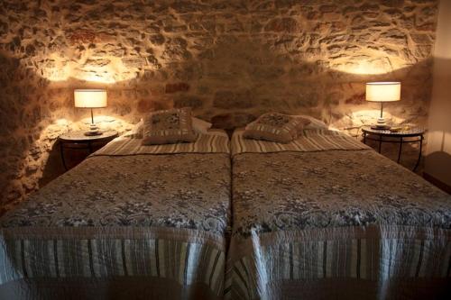a bedroom with a bed with two lamps on two tables at Gites la Filature in Laudun