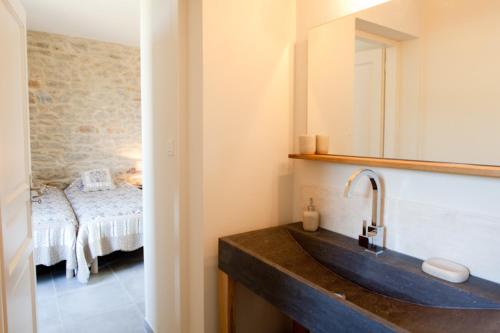 La salle de bains est pourvue d'un lavabo avec miroir et d'un lit. dans l'établissement Gites la Filature, à Laudun-l'Ardoise