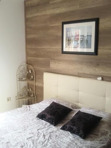 a bedroom with a white bed with a picture on the wall at Allegria in Umag