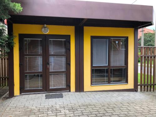 a yellow and black building with two doors at U Seckých in Rakvice