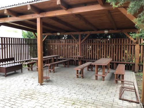 un gruppo di tavoli da picnic e panche sotto un padiglione in legno di U Seckých a Rakvice
