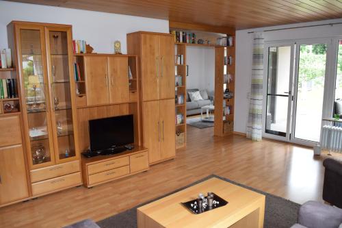 a living room with wooden cabinets and a flat screen tv at Ferienwohnung Gitta in Dietersheim