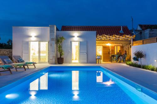 a villa with a swimming pool at night at Vila Gallo in Galovac