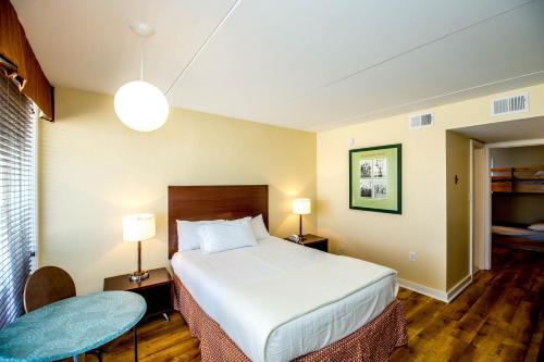 a hotel room with a bed and a table and lamps at Blue Palms Resort in Wildwood