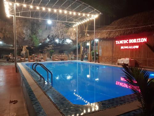 a large swimming pool in a building with lights at Tam Coc Horizon Bungalow in Ninh Binh