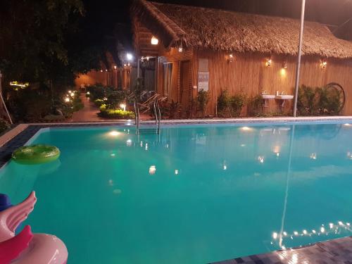 a swimming pool in front of a house at night at Tam Coc Horizon Bungalow in Ninh Binh