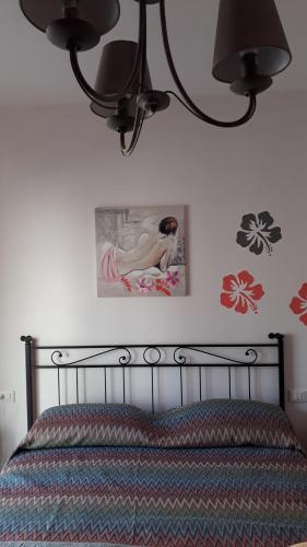 方狄的住宿－La rezztella，卧室配有一张床,墙上挂着一幅画