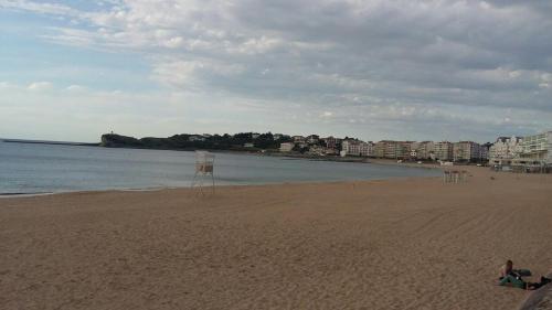 a beach with a few people sitting on the sand at Departamentos Suyana in Colón