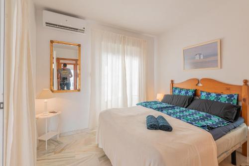 ein Schlafzimmer mit einem Bett mit zwei Schuhen drauf in der Unterkunft Tio Charles in Benalmádena