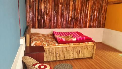 a small bed in a room with a wall at Vamoose Sunakhari in Mirik