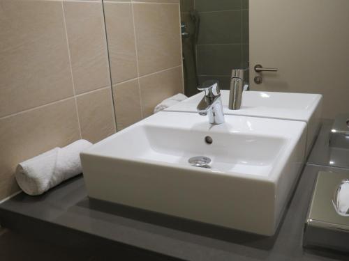 a bathroom with a white sink and a mirror at Garner Hotel Preston Samlesbury by IHG in Preston