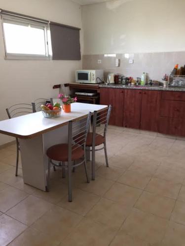 eine Küche mit einem Tisch und Stühlen sowie eine Küche mit einer Theke in der Unterkunft הבית של דרורי in Neve Zohar