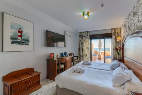 a bedroom with a bed and a television and a lighthouse at Hotel Playa de Regla in Chipiona