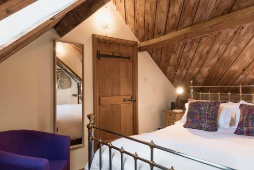 a bedroom with a bed and a wooden ceiling at Cottage 1 New Yatt Farm in Wilcote