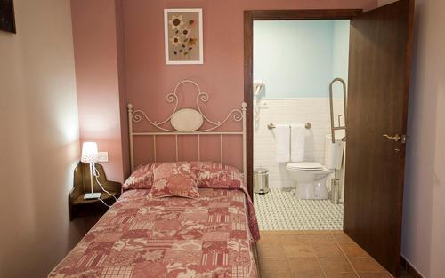 a bedroom with a bed and a bathroom with a toilet at Casa Rural Cinco Balcones in Aracena