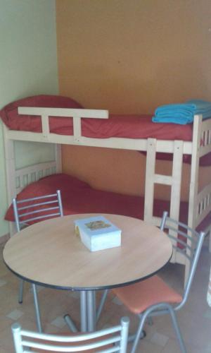 a table and chairs in a room with a bunk bed at Departamentos Suyana in Colón