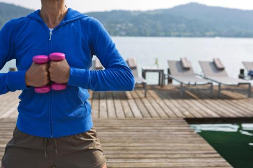 a man with pink gloves on a dock at Hotel Linde in Maria Wörth