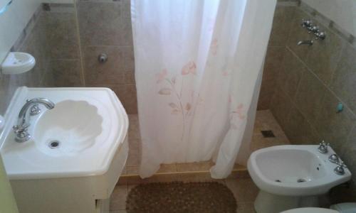 a bathroom with a sink and a toilet and a shower curtain at Departamentos Suyana in Colón
