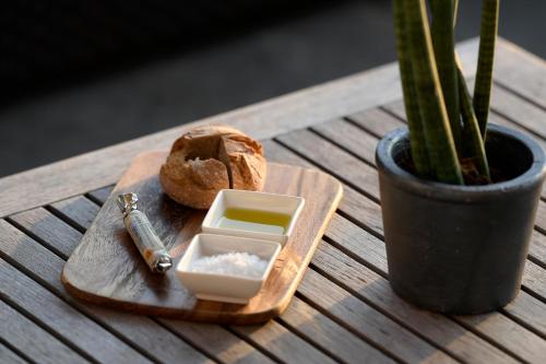 a wooden cutting board with a container of soap and a bread at Hotel Linde in Maria Wörth