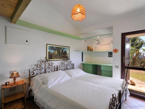 a bedroom with a white bed and a window at Villa Ibisco in Chia