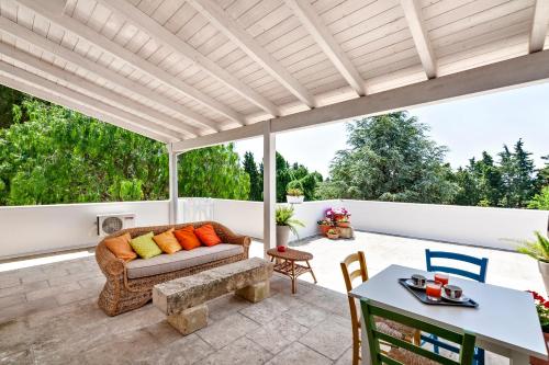 a patio with a couch and a table at Olive Garden House in Borgagne