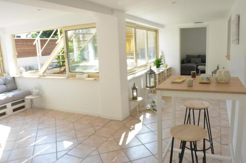 - une cuisine et un salon avec un comptoir et des tabourets dans l'établissement VILLA FLEUR DES PINS - 2 CHAMBRES - 3 étoiles BANC D ARGUIN, à Gujan-Mestras