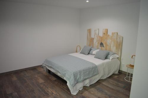 une chambre avec un lit avec une tête de lit en bois dans l'établissement VILLA FLEUR DES PINS - 2 CHAMBRES - 3 étoiles BANC D ARGUIN, à Gujan-Mestras